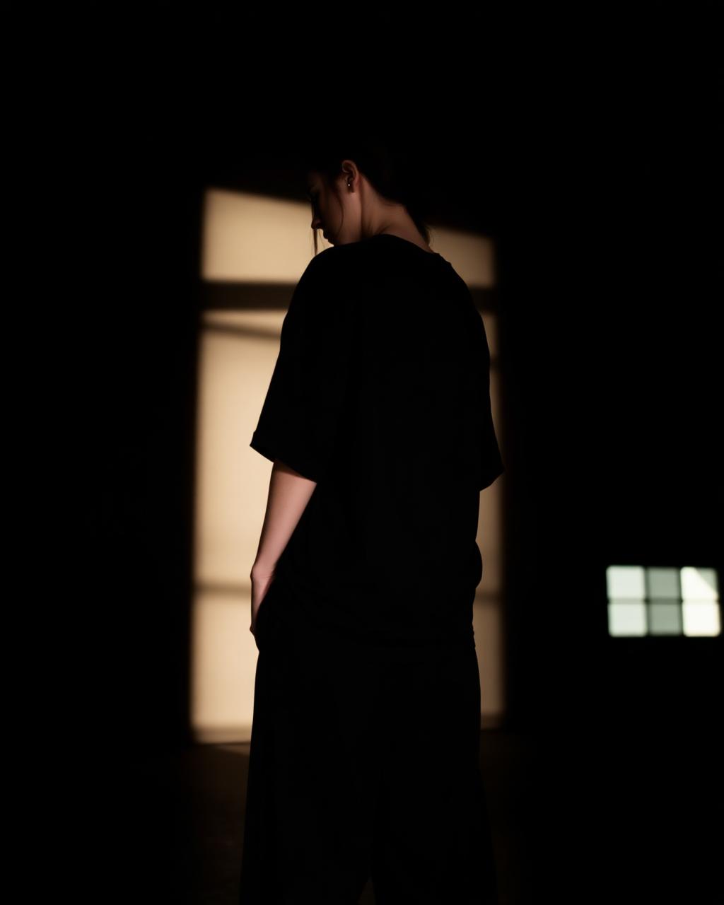 Editorial — back-lit silhouette in tee and wide pants